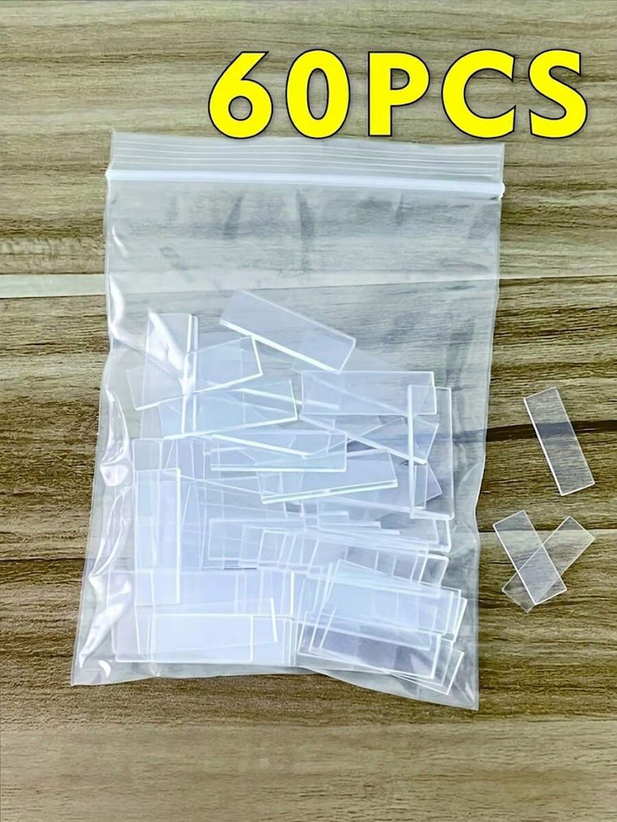 Clear plastic ziplock bag filled with many small, clear rectangular fire starter sticks on a wooden surface. Text: 60PCS